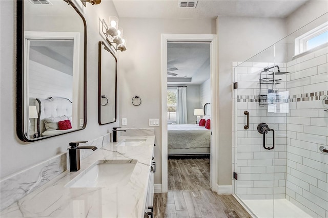 ensuite bathroom with wood finished floors, a sink, a shower stall, and ensuite bathroom