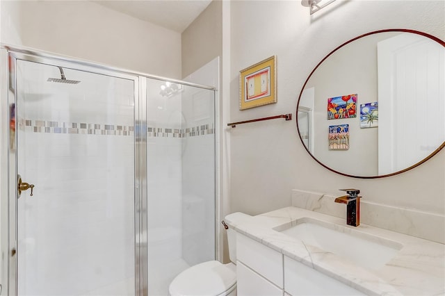 bathroom with toilet, a shower stall, and vanity