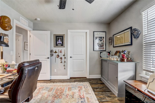 office area with visible vents, baseboards, ceiling fan, dark wood-style flooring, and a textured ceiling