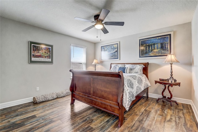 bedroom with a textured ceiling, dark wood-type flooring, a ceiling fan, and baseboards