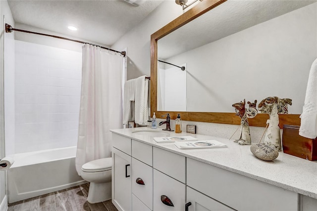 bathroom with toilet, wood finished floors, vanity, and shower / bathtub combination with curtain