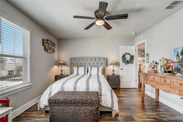 bedroom featuring dark wood-style floors, a textured ceiling, and visible vents