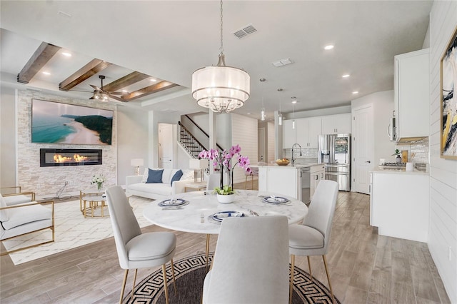 5618 Winterbrook Way, Winter Park, FL 32792 - dining space featuring stairway, a large fireplace, light wood-style flooring, a ceiling fan, and recessed lighting