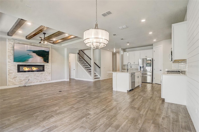 5618 Winterbrook Way, Winter Park, FL 32792 - kitchen featuring stainless steel appliances, open floor plan, a glass covered fireplace, light wood-style flooring, and recessed lighting