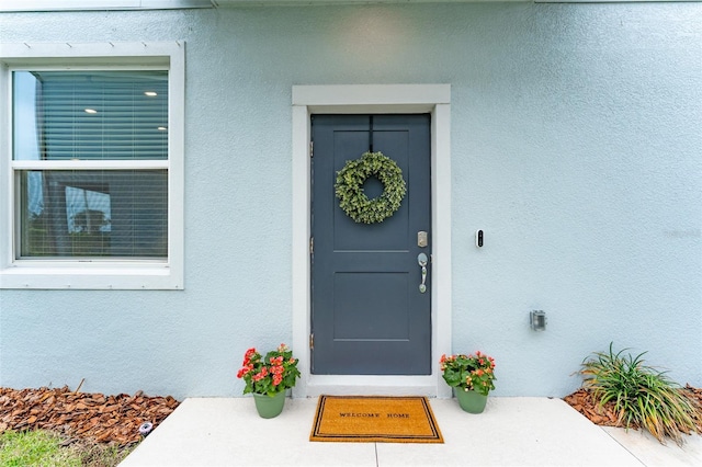 property entrance with stucco siding