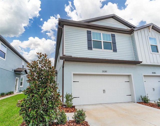 view of front of home featuring an attached garage, concrete driveway, and stucco siding