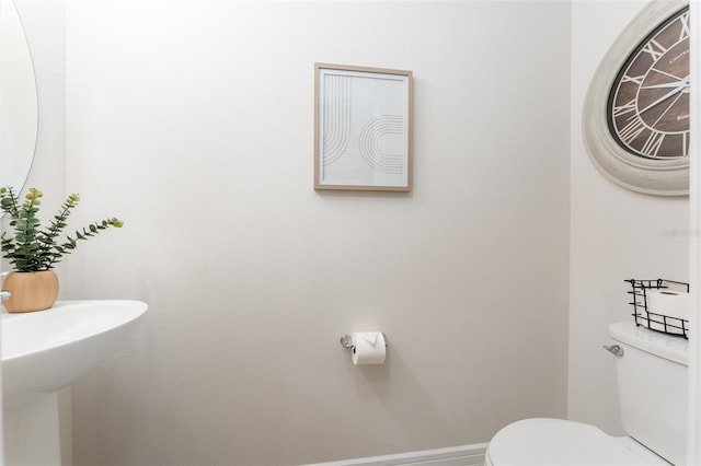 bathroom with toilet and baseboards