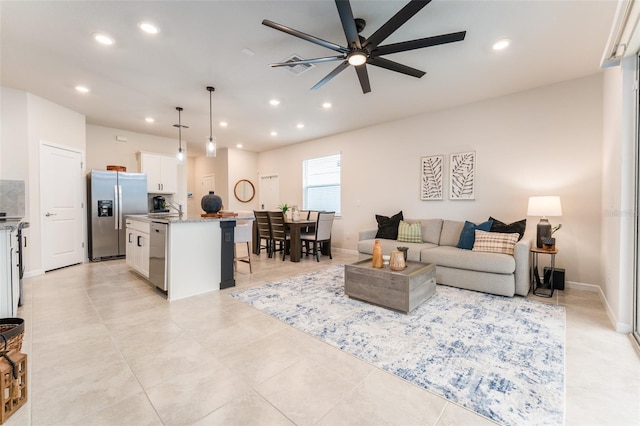 living area featuring ceiling fan, baseboards, and recessed lighting