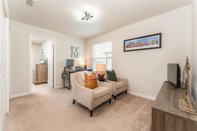 sitting room featuring light colored carpet, visible vents, and baseboards