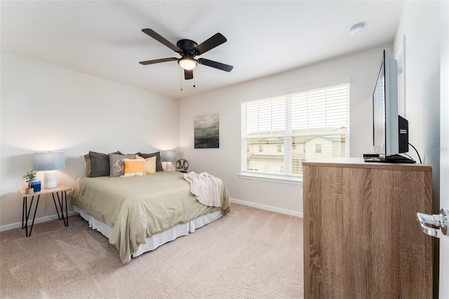 bedroom with light carpet, ceiling fan, and baseboards