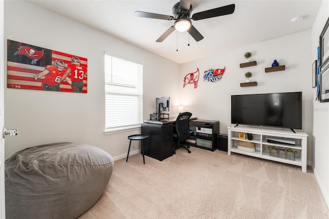 carpeted office space with ceiling fan and baseboards