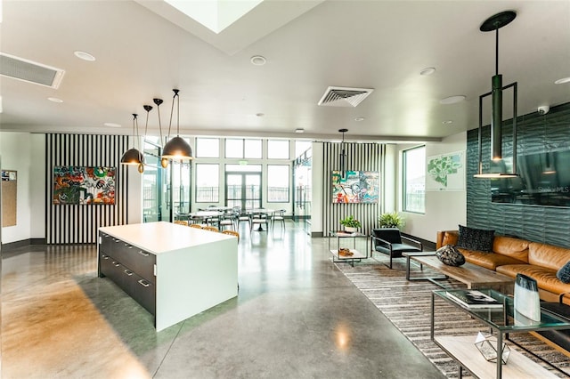 kitchen featuring baseboards, visible vents, concrete flooring, and a center island