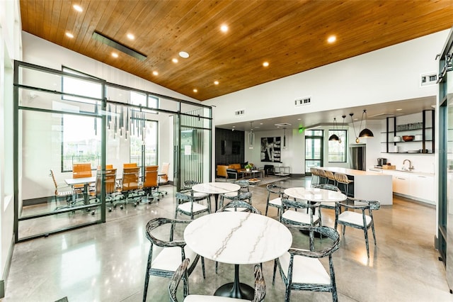 dining area featuring wood ceiling, concrete floors, visible vents, and recessed lighting