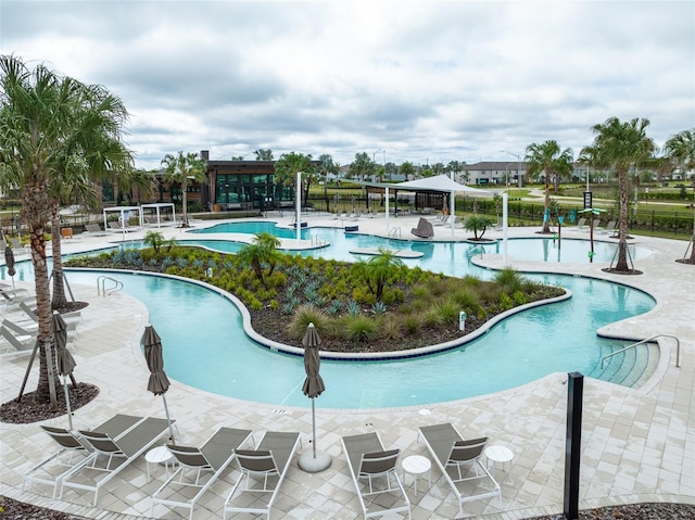 pool with a patio area and fence