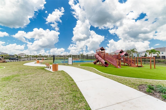 communal playground with fence and a lawn