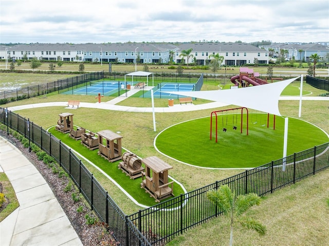 view of home's community with a tennis court, fence, and a residential view