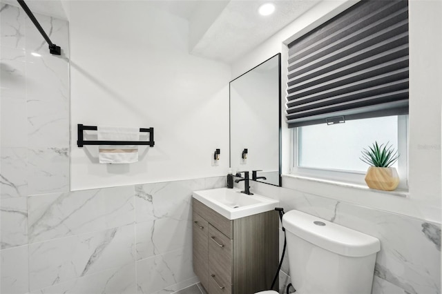 bathroom featuring a wainscoted wall, tile walls, recessed lighting, toilet, and vanity