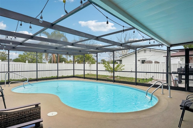 view of pool featuring glass enclosure, a fenced backyard, and a fenced in pool