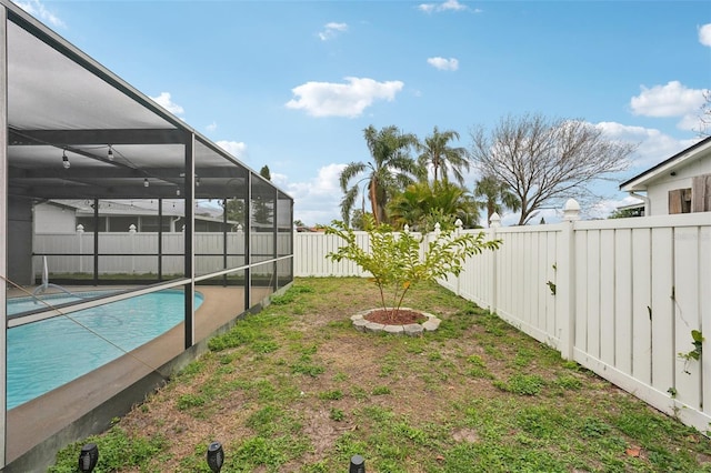 view of yard with a fenced backyard, a lanai, and a fenced in pool