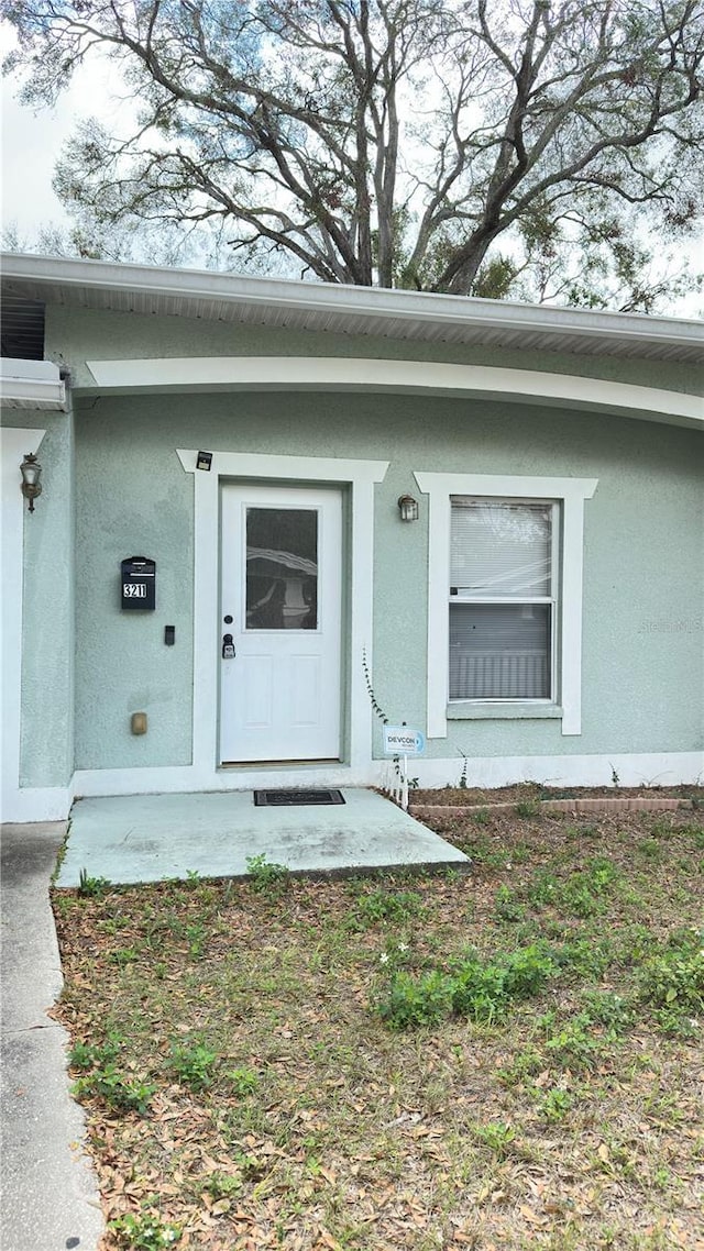 doorway to property with stucco siding