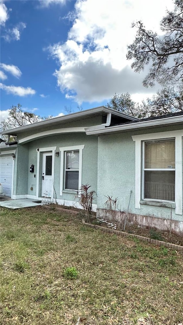 view of front of home with a front lawn and stucco siding