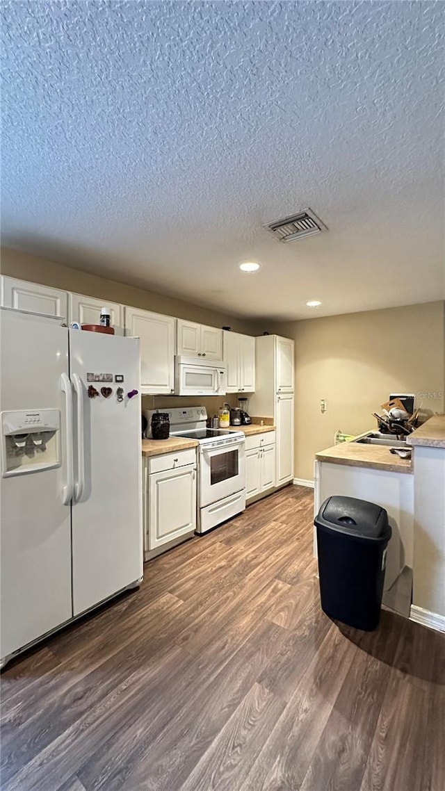 kitchen featuring white appliances, white cabinetry, and light countertops