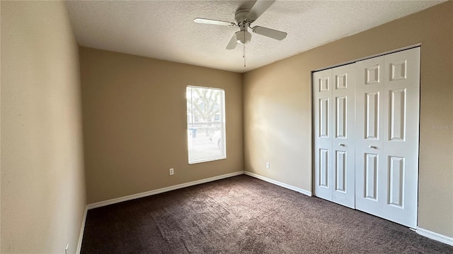 unfurnished bedroom with a closet, baseboards, dark carpet, and a textured ceiling