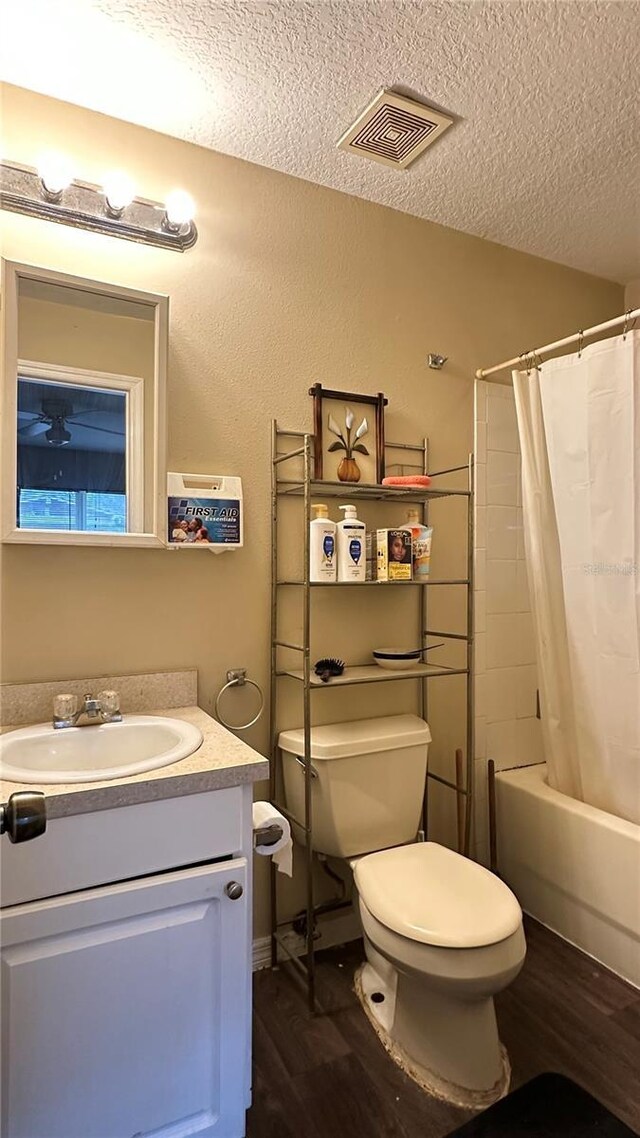 bathroom with visible vents, toilet, shower / tub combo, a textured ceiling, and wood finished floors