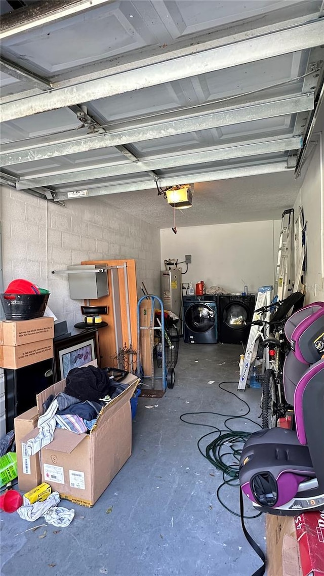 garage featuring a garage door opener, washing machine and dryer, water heater, and concrete block wall