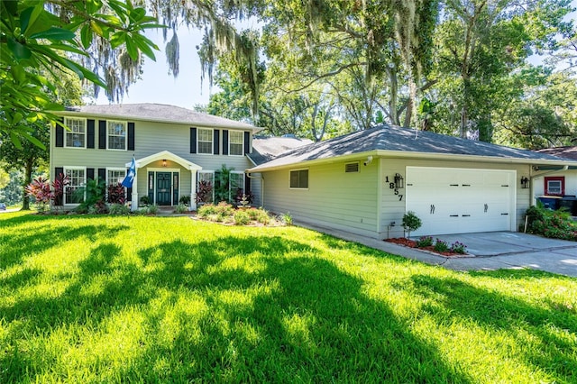 colonial inspired home with a front lawn, concrete driveway, and an attached garage