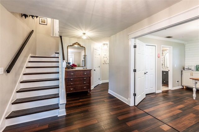 stairs featuring visible vents, crown molding, baseboards, and hardwood / wood-style flooring