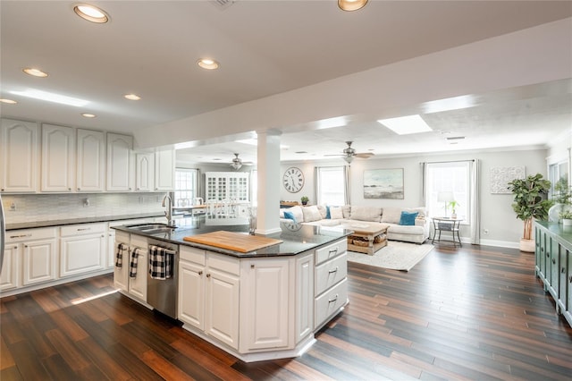 kitchen with open floor plan, dark countertops, and white cabinetry