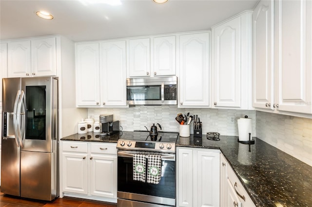 kitchen featuring white cabinets, dark wood finished floors, dark stone counters, decorative backsplash, and stainless steel appliances