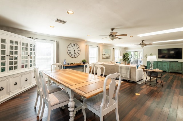 dining room featuring dark wood finished floors, visible vents, and a healthy amount of sunlight