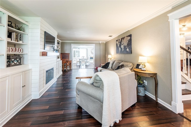 living area featuring a large fireplace, dark wood-type flooring, baseboards, stairway, and crown molding