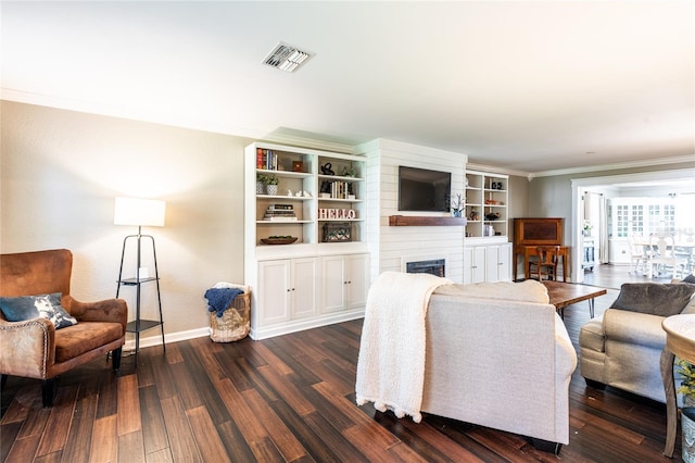 living room with visible vents, dark wood-type flooring, ornamental molding, a large fireplace, and baseboards