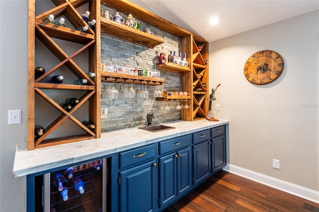 wine cellar featuring baseboards, wine cooler, dark wood-style flooring, wet bar, and a sink