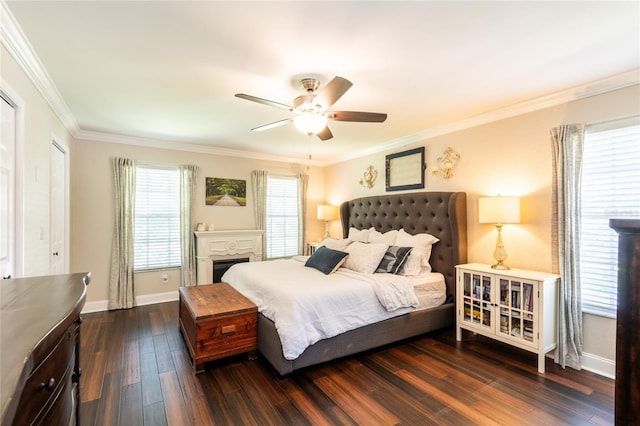 bedroom featuring ceiling fan, a fireplace, baseboards, ornamental molding, and dark wood finished floors