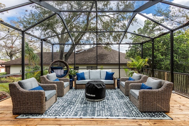 view of patio with glass enclosure, outdoor lounge area, and a wooden deck