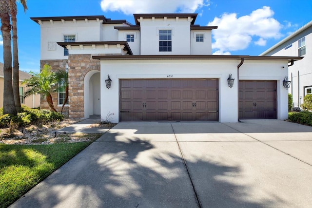 view of front of property featuring a garage, stone siding, concrete driveway, and stucco siding