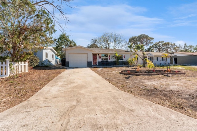 ranch-style home with driveway, an attached garage, fence, and a residential view