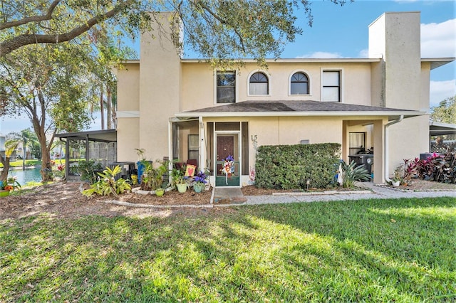 view of front facade featuring a front yard, a sunroom, and central AC