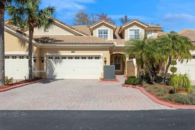 view of front of home with central AC and a garage