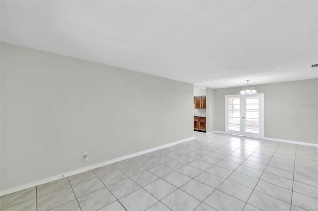 tiled empty room with a chandelier