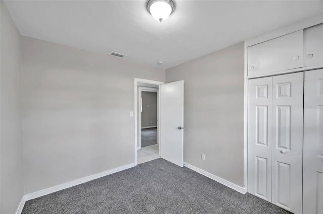 unfurnished bedroom with a closet and light colored carpet