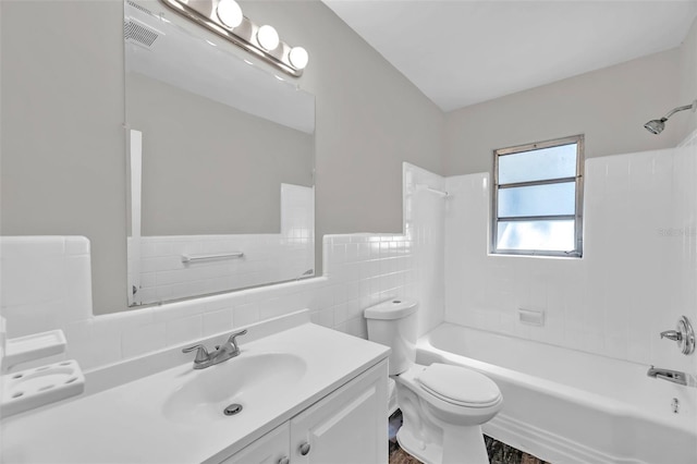 full bathroom featuring vanity, tile walls, toilet, and tiled shower / bath