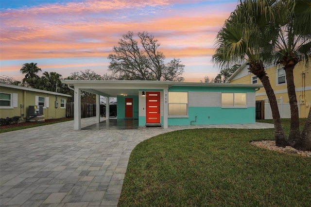 view of front of home with decorative driveway and a front yard