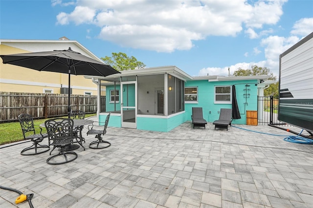 exterior space featuring a sunroom and fence