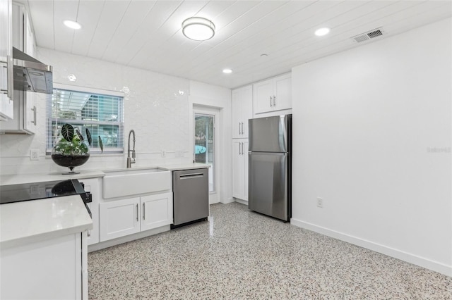 kitchen featuring a sink, stainless steel appliances, light countertops, and white cabinets