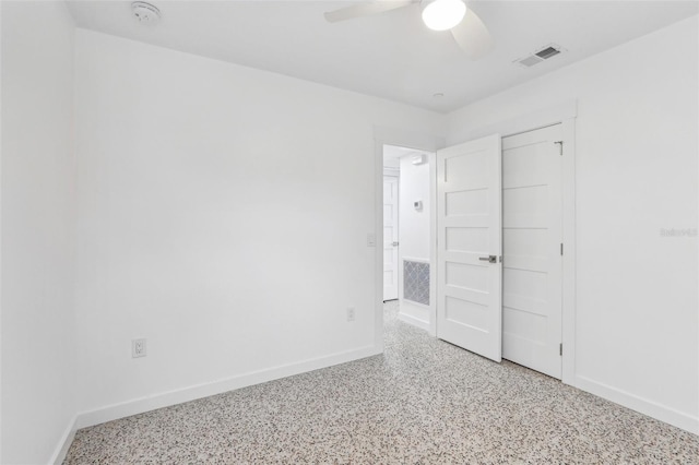 unfurnished bedroom with a ceiling fan, visible vents, baseboards, and speckled floor